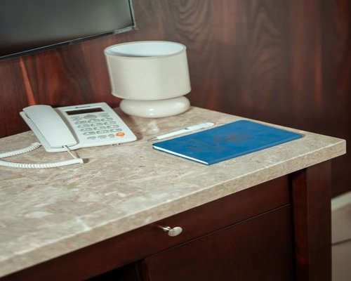 A wooden desk with a telephone and an open notebook