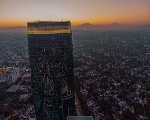 Panoramic view of Mexico City featuring modern buildings and distant mountains