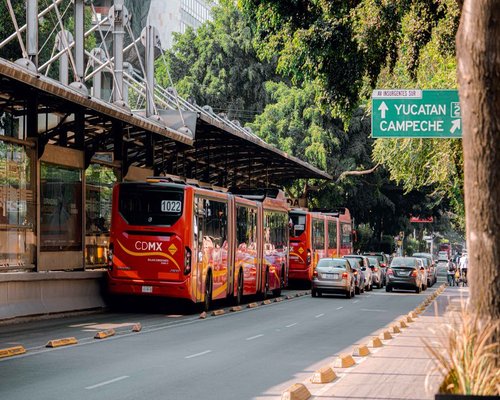 A public bus Metrobús arriving at a busy station in Mexico